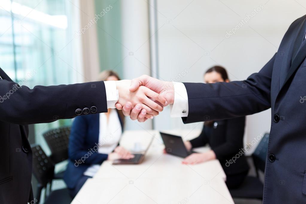 Business shaking hands in the office, finishing a meeting