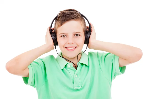 Portrait of smiling young boy listening to music on headphones a — Stock Photo, Image