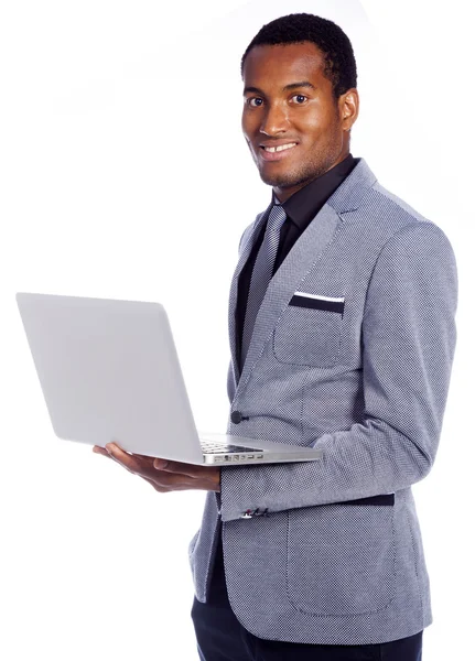 Jovem homem de negócios segurando um laptop no fundo branco — Fotografia de Stock