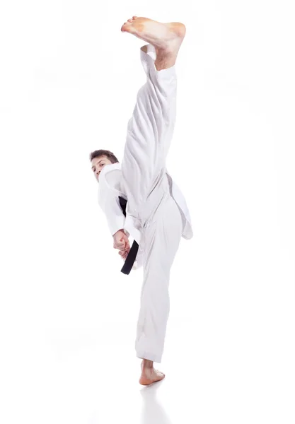 Jovem praticando artes marciais sobre fundo branco — Fotografia de Stock