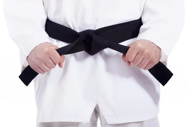 Homem de artes marciais amarrando seu cinto preto, isolado em branco — Fotografia de Stock