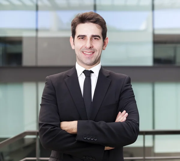 Retrato de un hombre de negocios guapo sonriente en el edificio de oficinas —  Fotos de Stock