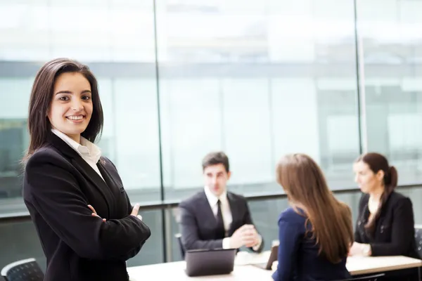 Geschäftsfrau lächelt im Vordergrund seines Teams — Stockfoto