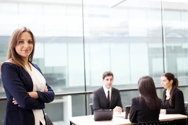 Smiling businesswoman on the foreground of his team — Stock Photo, Image
