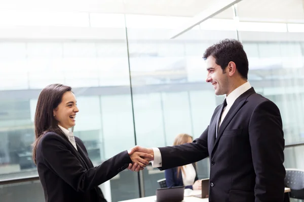 Glückliche Geschäftsleute beim Händeschütteln im Büro — Stockfoto