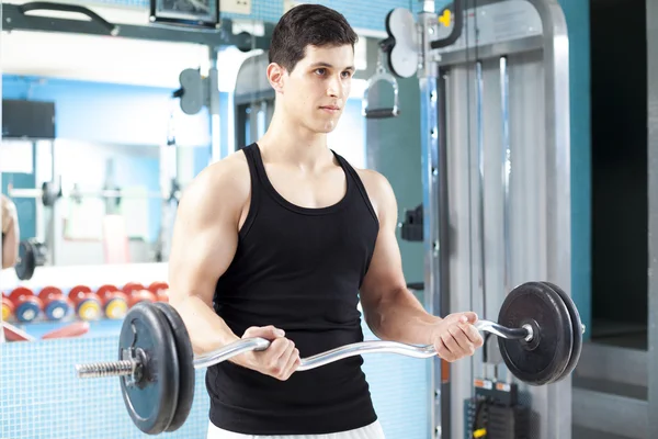 Beau homme soulevant des poids lourds libres à la salle de gym — Photo