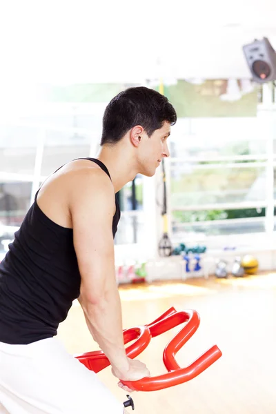 Bonito jovem fazendo esporte Spinning no ginásio para fitness — Fotografia de Stock