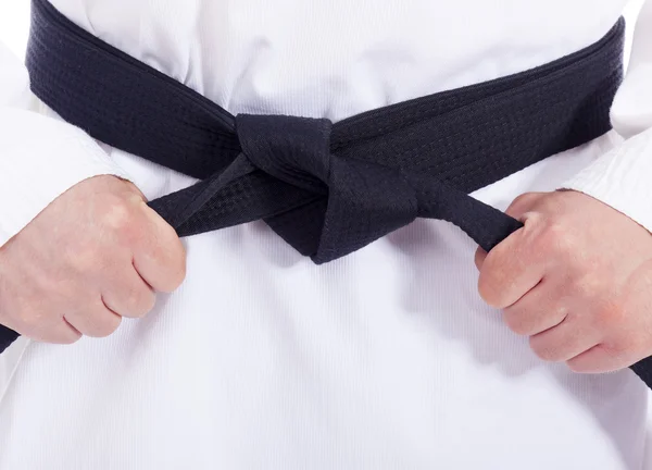 Closeup of a martial arts man tying his black belt Stock Image