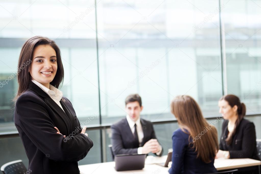 Businesswoman smiling on the foreground of his team