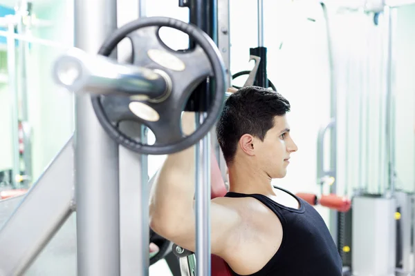 Hombre guapo levantar pesas pesadas en el gimnasio —  Fotos de Stock