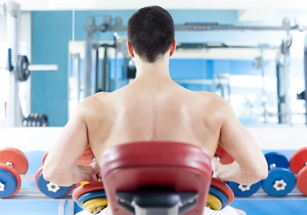 Hombre guapo de entrenamiento de espalda con pesas en el gimnasio —  Fotos de Stock
