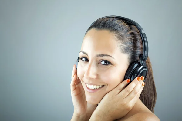 Portrait d'une jeune femme avec écouteurs écoutant de la musique — Photo