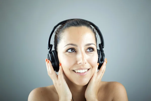 Retrato de una joven con auriculares escuchando música — Foto de Stock