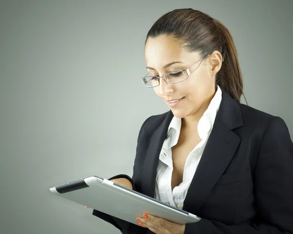 Usmívající se žena držící tabletový počítač šedé pozadí — Stock fotografie