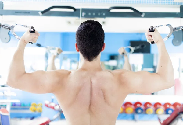 Forte homem bonito exercitando suas costas no ginásio — Fotografia de Stock