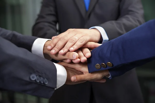 Equipo de negocios mostrando unión con sus manos juntas formando una pila — Foto de Stock