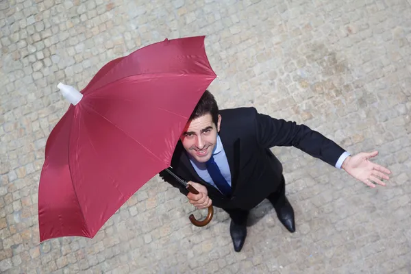 Businessman with umbrella checking if it's raining — Stock Photo, Image