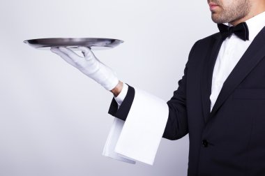 profesyonel garson boş gümüş tepsi üzerinde gri backgrou holding
