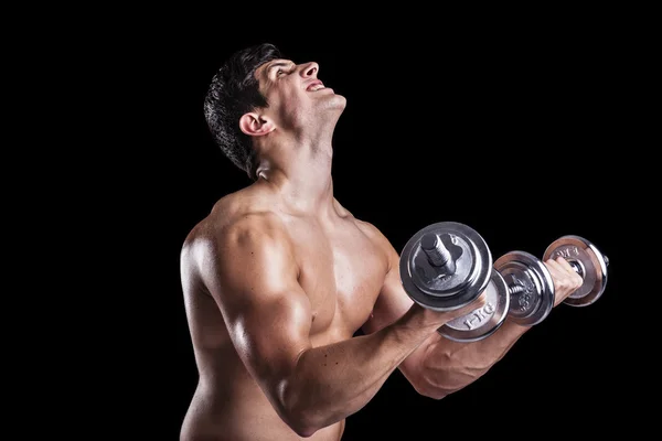 Porträt eines starken Mannes, der vor dunklem Hintergrund Gewichte stemmt — Stockfoto