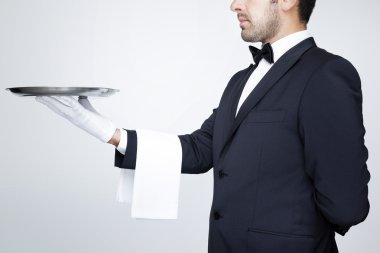 boş bir gümüş tepsi tutarak profesyonel garson