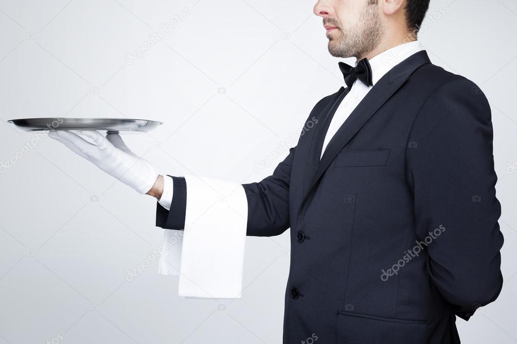 Professional waiter holding an empty silver tray