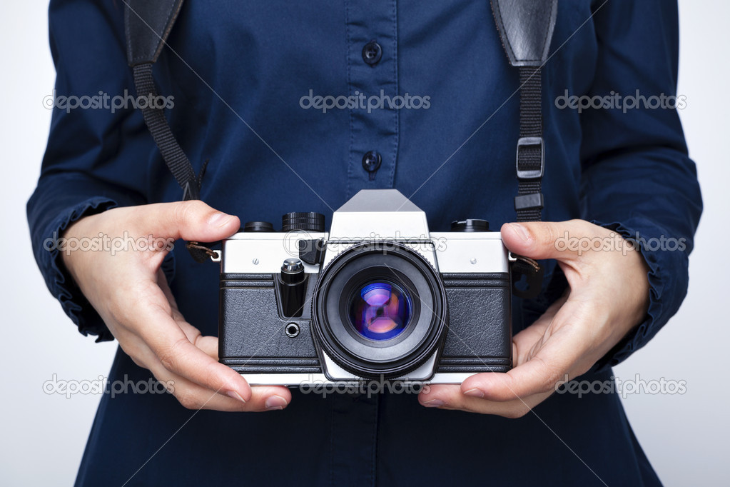 Woman holding a camera over gray background
