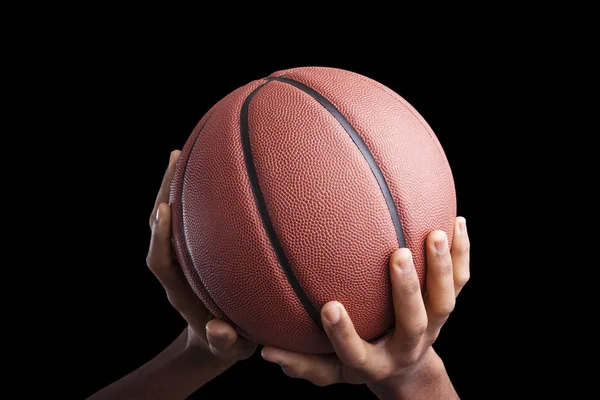 Koszykarz trzymając piłkę w ciemnym tle — Zdjęcie stockowe