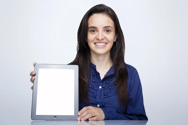 Mulher de negócios segurando um computador tablet contra fundo cinza — Fotografia de Stock
