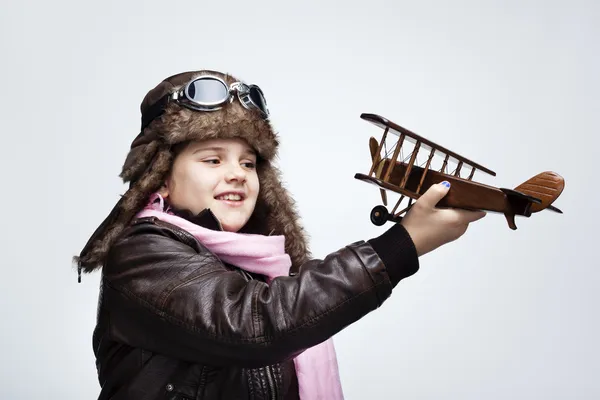 Happy child playing with toy airplane against gray background — Stock Photo, Image