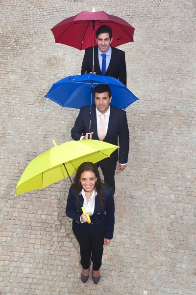 Деловые люди с разноцветными зонтиками — стоковое фото