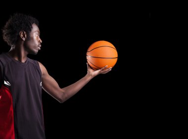 bir top karşı karanlık geri tutan bir basketbolcu portresi