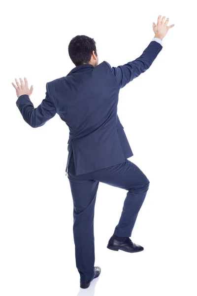 Handsome businessman climbing a wall, isolated on white — Stock Photo, Image