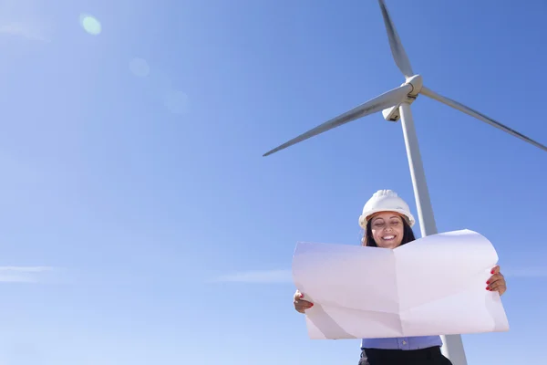 Жінка-інженер тримає креслення на вітроелектростанції — стокове фото