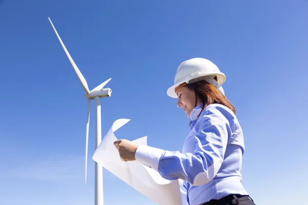 Ingeniera femenina sosteniendo un plano en el parque eólico — Foto de Stock