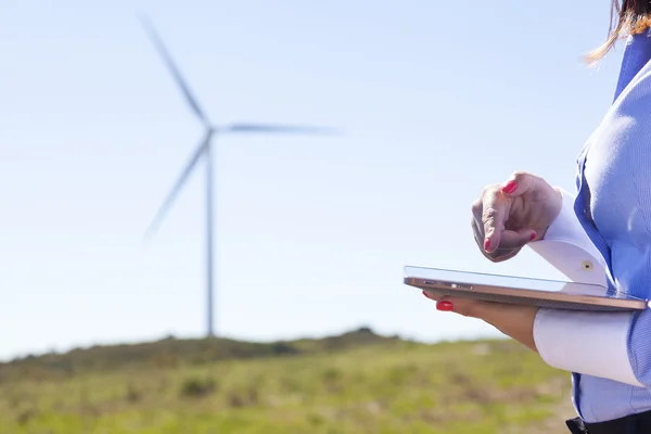 Närbild av en kvinnlig ingenjör som arbetar med en tablett på wind farm — Stockfoto