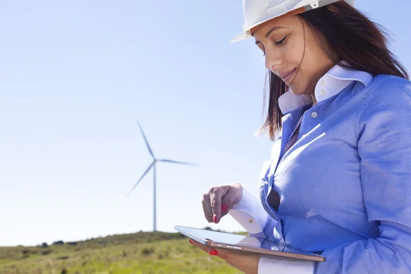 Kvinnliga ingenjör som arbetar med en tablett på wind farm — Stockfoto