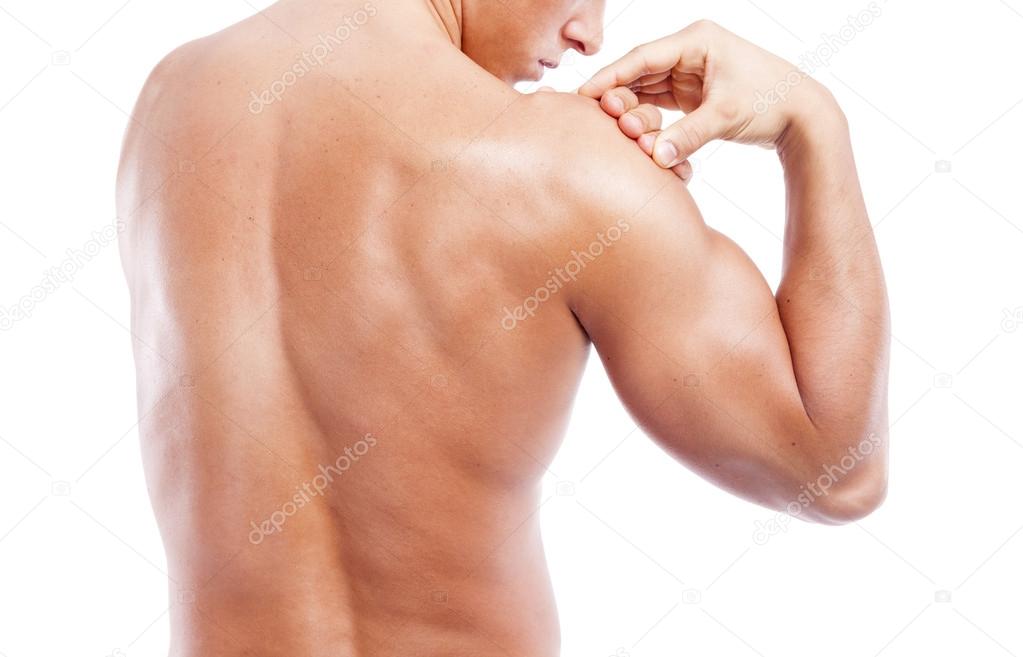 Muscular man holding his shoulder