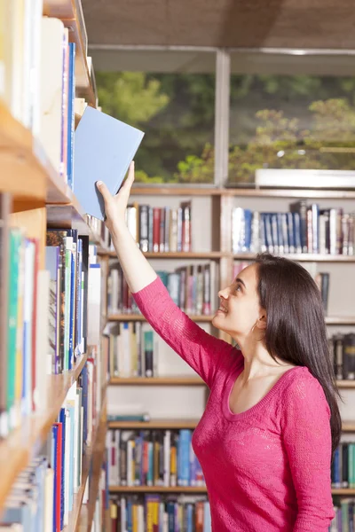 Student picking a book — Stock Photo, Image