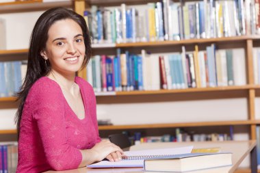bir kitaplıkta eğitim gülümseyen kız öğrenci