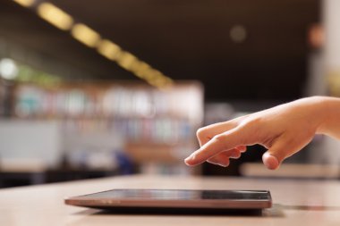 tablet bilgisayar kitaplığı işaret eden el