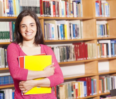 kütüphaneden kitap tutan mutlu kız öğrenci