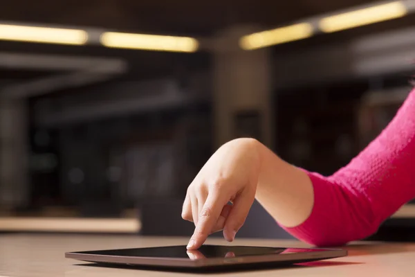 Hand zeigt auf Tablet-Computer in Bibliothek — Stockfoto
