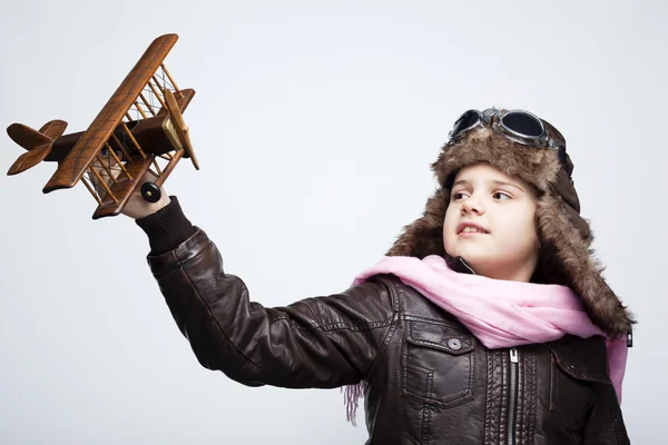 Enfant heureux jouant avec un avion jouet sur fond gris — Photo