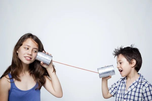 Дети используют банку в качестве телефона — стоковое фото