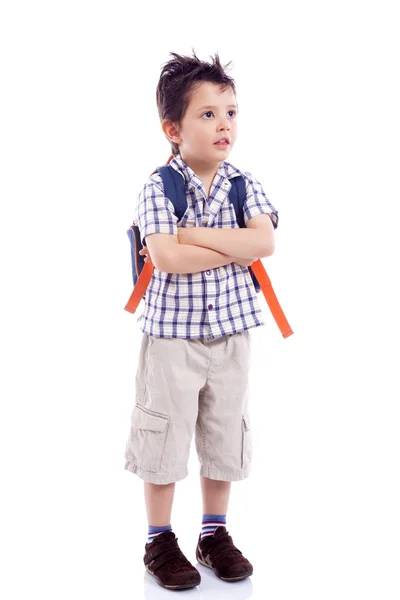 Niño sonriente de la escuela de pie con los brazos cruzados contra la espalda blanca — Foto de Stock