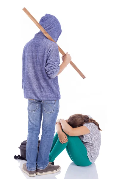 Jongen een houten stok houden geslagen op een klein meisje, geïsoleerd — Stockfoto