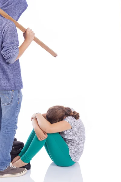 Boy holding a wooden stick to beaten on a little girl, isolated — Stock Photo, Image