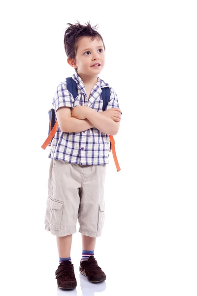 Ragazzo sorridente scuola in piedi con le braccia incrociate contro la schiena bianca — Foto Stock