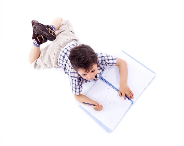 Ovan syn på skolpojke rita med blyerts på anteckningsboken, isolera — Stockfoto
