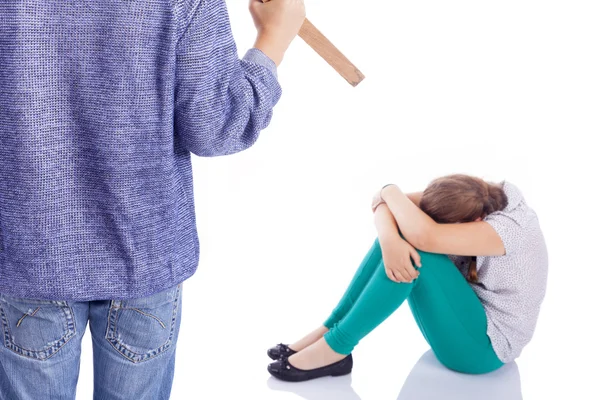 Boy holding a wooden stick to beaten on a little girl, isolated — Stock Photo, Image